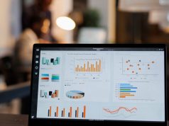 Diferencia entre SEO y SEM y cuánto cuesta contratar cada uno Portátil con gráficos de estadísticas de marketing en una oficina