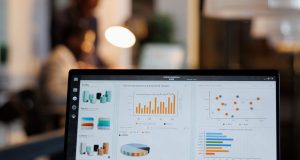 Diferencia entre SEO y SEM y cuánto cuesta contratar cada uno Portátil con gráficos de estadísticas de marketing en una oficina