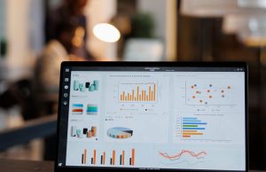 Diferencia entre SEO y SEM y cuánto cuesta contratar cada uno Portátil con gráficos de estadísticas de marketing en una oficina